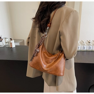 Retro brown leather shoulder bag detail with amber bead and cartoon doll charm decoration