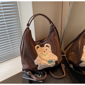 Gros plan du sac hobo marron avec broderie ours en peluche et boucles métalliques