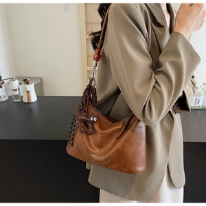 Brown leather shoulder bag with amber beads and a cute cartoon cat pendant detail