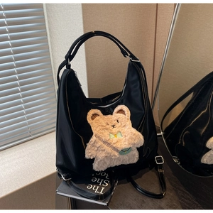 Détail du sac cabas noir avec ornement d'ours en peluche 3D et bandoulière réglable