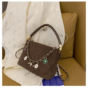 Close-up of matte dark brown quilted bucket bag with golden heart charm chain strap