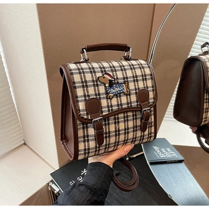 Detail of vintage canvas check bag with dachshund embroidery and brown leather trim