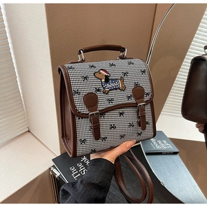 Detail of houndspur backpack featuring classic pattern and dog embroidery