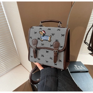 Detail of retro houndstooth pattern and cute puppy embroidery on a stylish backpack