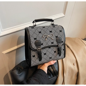 Close-up of retro gray jacquard fabric with black bow patterns and silver metal buckle