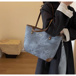 Detailed close-up of large marble texture tote bag with brown leather handles and base