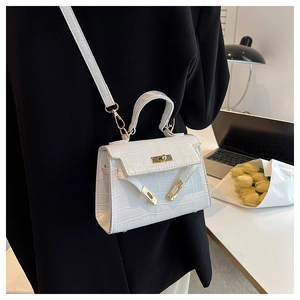 Detailed close-up of white crocodile pattern Kelly bag with gold buckle on a desk