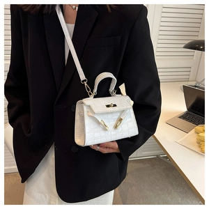 Detail view of white crocodile pattern Kelly bag with gold metal buckle and handle