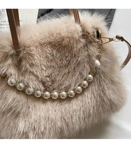 Gros plan détaillé d'un sac à main beige en fausse fourrure avec chaîne de perles élégante