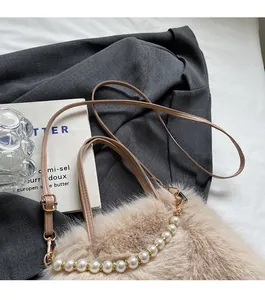 Détail du sac à main en peluche avec poignée en perles et bandoulière réglable en cuir