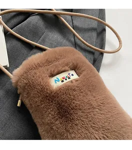 Gros plan du sac bandoulière en peluche marron avec fourrure douce et étiquette NAKALIN