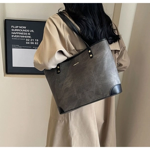 Detail of a large textured tote bag with vintage marble patterns and metallic hardware