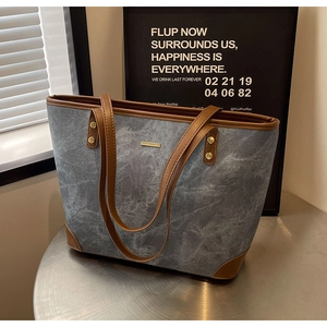 Close-up of marble texture tote bag with brown leather trim and gold rivet accents