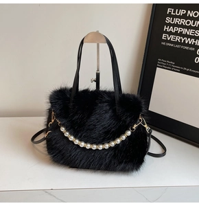Détail du sac à main en fausse fourrure noire avec chaîne de perles et crochets dorés