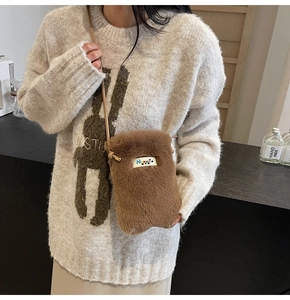 Détail du sac bandoulière en peluche marron avec fourrure douce et étiquette tissée