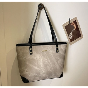 Detail view of large marble pattern tote bag with black trim and gold metal buckle
