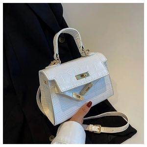 Detail of white crocodile pattern Kelly bag with gold metal buckle and leather strap