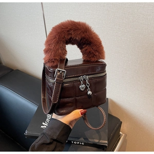 Detailansicht der braunen Stepptasche mit flauschigem Pelzgriff und Herz-Anhänger-Detail