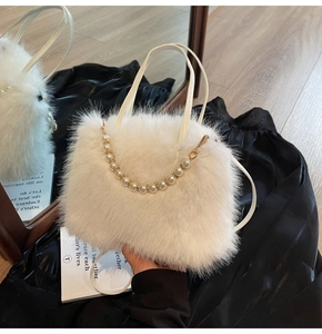 Détail d'un sac à main en fausse fourrure blanche avec chaîne en perles et métal doré