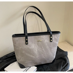Detail of grey marble texture tote bag with black leather trim and golden rivets
