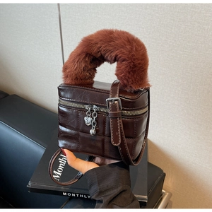 Detail der braun gesteppten Kunstledertasche mit Herz-Reißverschluss und flauschigem Griff