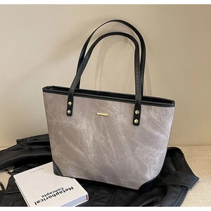 Close-up of minimalist marble texture tote bag with black leather edges and gold hardware