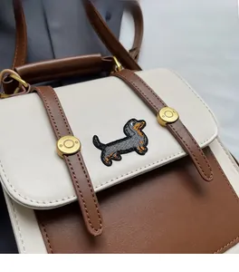 Detail of vintage contrast color bag featuring exquisite dachshund embroidery and leather