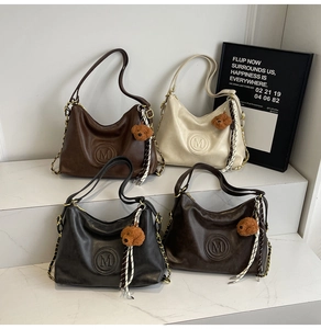 Detail view of four large retro hobo backpacks with M-logo embossing and bear charms