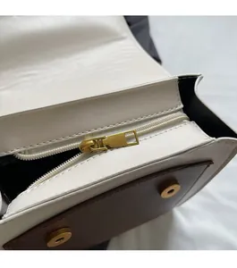 Detail of smooth white and brown leather bag with golden zipper and magnetic buckles