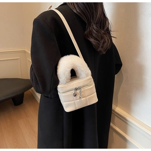 Detailansicht der weißen gesteppten Box-Tasche mit flauschigem Kunstpelzgriff und Herzanhänger