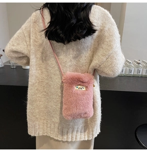 Détail du petit sac bandoulière en peluche rose avec texture douce et boucles dorées