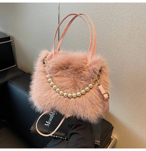 Détail du sac à main en fausse fourrure rose montrant la texture et la chaîne de perles