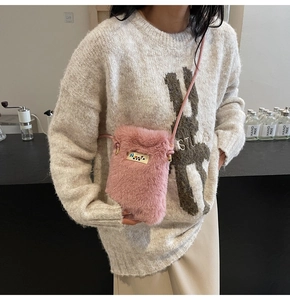Détail d'une pochette de téléphone rose en fausse fourrure avec logo métallique