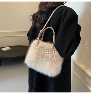 Détail d'un sac à main en peluche beige orné de perles blanches élégantes sur le dessus