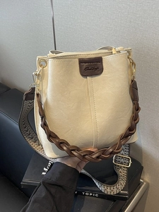 Chic beige bucket bag with dark brown leather details and ethnic jacquard wide strap