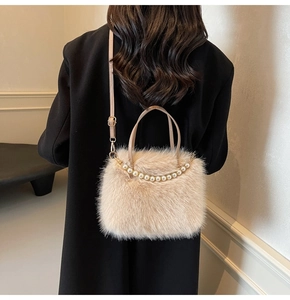 Gros plan du sac à main en peluche crème avec une élégante chaîne de perles blanches