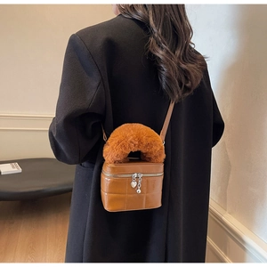 Detail der braunen Stepptasche mit Kunstfellgriff und Herz-Reißverschlussanhänger