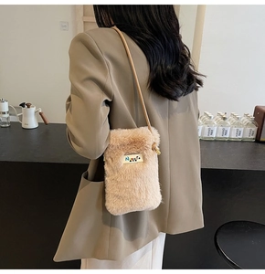 Détail d'un sac bandoulière en peluche douce avec fourrure synthétique et logo en métal