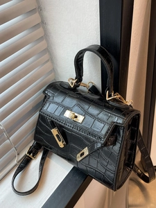 Elegant black crocodile-embossed Kelly-style handbag with golden hardware and top handle