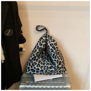 Plüsch-Tragetasche mit Leopardenmuster und goldenem Metallemblem auf Koffer