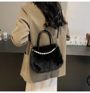 Détail d'un sac à bandoulière en fausse fourrure noire avec chaîne de perles blanches