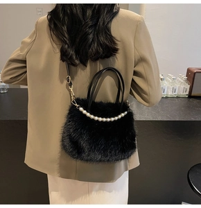 Détail d'un sac à main en fausse fourrure noire avec poignée en perles et bandoulière