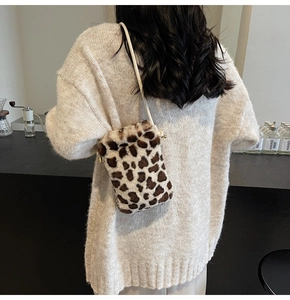 Détail d'un sac bandoulière en fausse fourrure léopard porté avec fine bandoulière