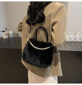 Détail du sac à main en fausse fourrure noire avec perles élégantes et boucles dorées