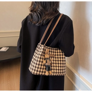 Brown checkered tote bag with leather straps and a cute plush rabbit accessory
