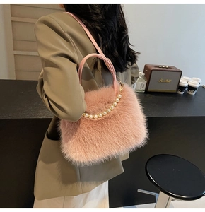 Détail du sac à main en fausse fourrure rose avec anse perlée et bandoulière amovible