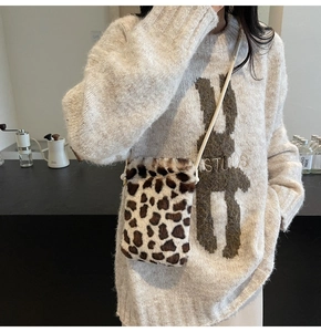 Gros plan sur un mini sac bandoulière en fausse fourrure léopard avec un pull en maille