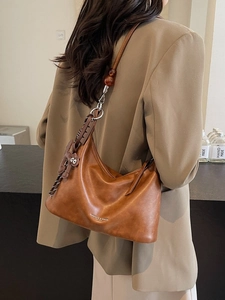 Minimalist caramel brown crescent underarm bag with cat charm and beaded shoulder strap