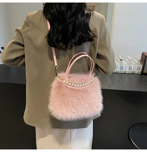 Détail du sac en fausse fourrure rose avec anse en perles et crochets en métal doré