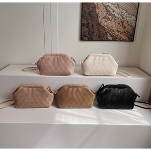 Kollektion plissierter Umhängetaschen in fünf eleganten Farben auf einem Display